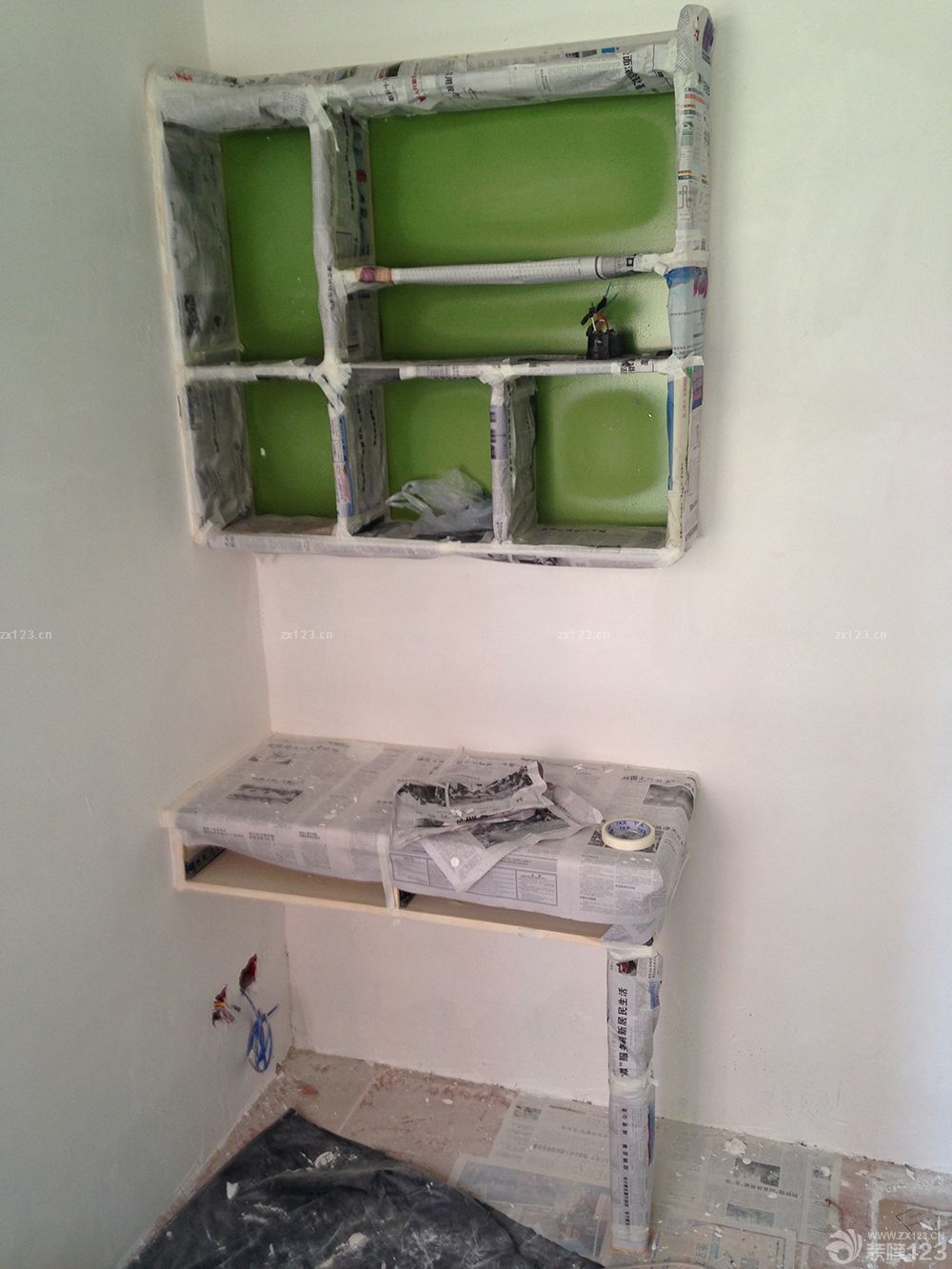 　　因?yàn)橛推徇@味道，整個噴漆過程我一點(diǎn)也沒參與，直接躲的遠(yuǎn)遠(yuǎn)的!等我再回房子看的時(shí)候，油工師傅用報(bào)紙都給包上了，直接就進(jìn)入刮石膏的程序了。。<br><br>　　墻上的小木板：其實(shí)是防腐木板，陽臺的地臺剩的板，退又退不了，仍了還可惜是不!特意讓木工師傅打了三條小木板，雙層的，以后掛個吊蘭啊，照片墻啊，這個啊，那個啊，什么什么的啊，沒想好呢，反正是會各種被利用起來。<br><br>　　次臥的書桌，已經(jīng)都包上了，懸空的書架，其實(shí)書桌之前也是懸空的，后來怎么看怎么覺得不穩(wěn)妥，怕以后寶寶在地上玩撞到頭，就后加了一條桌腿。<br><br>　　等大白干透了之后，直接噴了乳膠漆，只噴了棚頂。墻面全貼壁紙。<br>