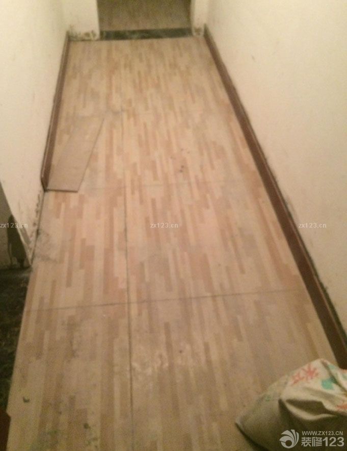 　　本來(lái)想鋪地板的，資金實(shí)在緊張就鋪了地磚，不過(guò)紋理很像地板也不貴，一片才35，綜合下來(lái)比地板省了1500左右吧!衛(wèi)生間干區(qū)的瓷磚也是按照設(shè)計(jì)師設(shè)計(jì)的差不多買(mǎi)的，正好找到了差不多的，給大家看看瓦工結(jié)束的照片，昨天去的時(shí)候有點(diǎn)晚了，改完電只有走廊的燈能打開(kāi)，照的不太好，改天再給大家多發(fā)幾張看買(mǎi)的地磚是不是很像地板。<br>